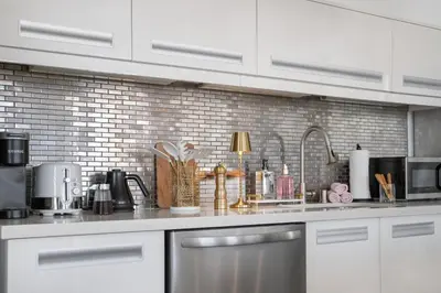 a kitchen with white cabinets and a counter top at Stylish loft 2 queens & 2 sofas in Los Angeles