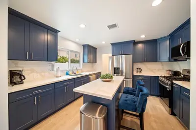 a large kitchen with blue cabinets and a counter top at Hidden South Bay Gem near Manhattan and Redondo Beach in Redondo Beach