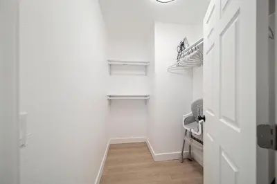 a bathroom with white walls and a door and wooden floors at Hidden South Bay Gem near Manhattan and Redondo Beach in Redondo Beach