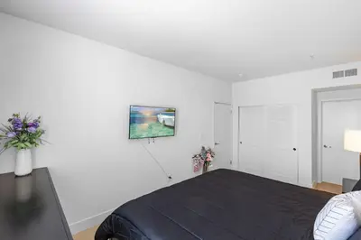 a bedroom with a bed and a white wall at 12 Best Location Cozy Apartment in Los Angeles