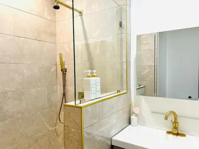 a bathroom with a shower and a toilet and a sink at Newly Gated Stylish Steps to Hollywood 2B2B in North Sherman Way