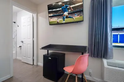 a room with a television on a wall with a chair at La Casita Inn in Wilmington