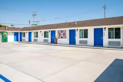 a row of white buildings with blue doors at La Casita Inn in Wilmington
