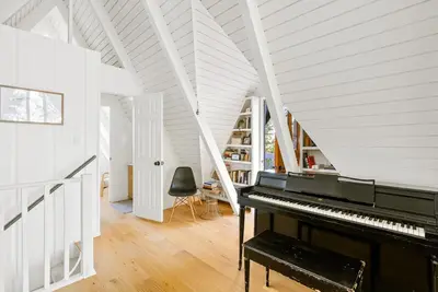 a piano in a room with a white ceiling at Luxury A-Frame Retreat in Lake Arrowhead