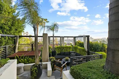 a garden with palm trees and a table and chairs at Hollywood Hills 3 Bedroom Views and Jacuzzi in Los Angeles
