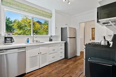 a kitchen with white cabinets and a large window at Modern piano Los Angeles home by universal studio & Hollywood for 10 in Studio City