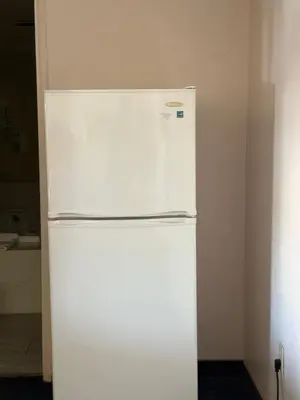 a white refrigerator freezer sitting in a room at Fiesta Inn Los Angeles - Bell Gardens in Bell Gardens