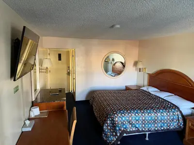 a hotel room with a bed and a mirror at Fiesta Inn Los Angeles - Bell Gardens in Bell Gardens