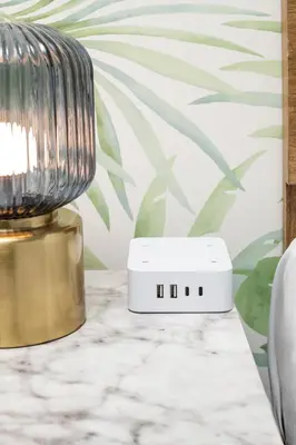 a table with a lamp and a alarm clock at The LEEF Hotel in Glendale