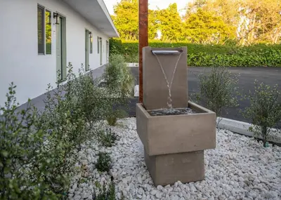 a garden with a fountain in the middle of a yard at The LEEF Hotel in Glendale