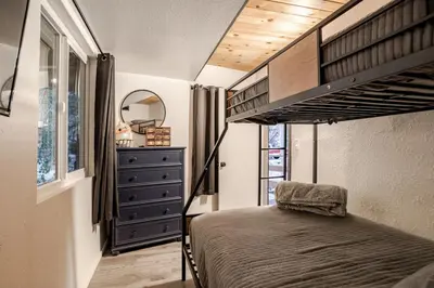 a bedroom with a bunk bed and a dresser at Snow Valley Retreat With Spa in Running Springs