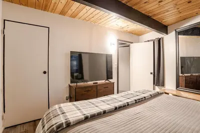 a bedroom with a bed and a flat screen tv at Snow Valley Retreat With Spa in Running Springs