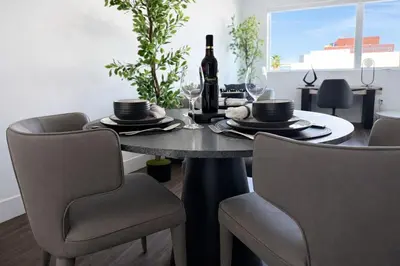 a dining room table with a bottle of wine and chairs at Designer 1 Bedroom Condo in Prime Hollywood in Los Angeles