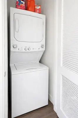 a white refrigerator freezer sitting next to a door at Designer 1 Bedroom Condo in Prime Hollywood in Los Angeles