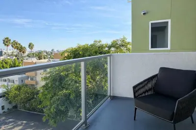 a chair sitting on the balcony of a building at Designer 1 Bedroom Condo in Prime Hollywood in Los Angeles