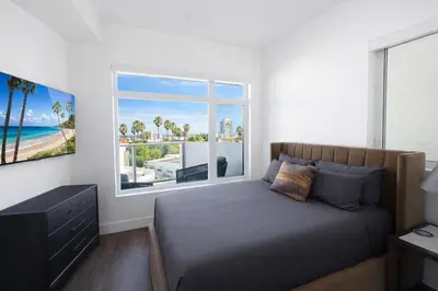 a bedroom with a bed and a large window at Designer 1 Bedroom Condo in Prime Hollywood in Los Angeles