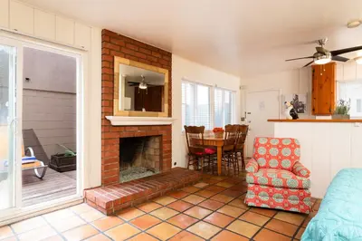 a living room with a fireplace and a chair and a table at The Sea View Inn At The Beach in Manhattan Beach
