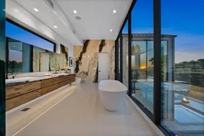 a bathroom with two sinks and a large window at Ocean to City Views, Fire Feature, Water falls Dream Oasis in Los Angeles