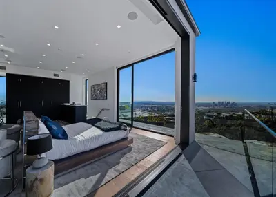 a bedroom with a bed and a large glass window at Ocean to City Views, Fire Feature, Water falls Dream Oasis in Los Angeles