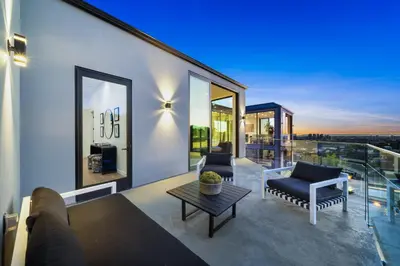 a living room with a couch and a table on a balcony at Ocean to City Views, Fire Feature, Water falls Dream Oasis in Los Angeles