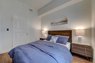 a bedroom with a bed with a blue comforter at Ocean View Suite by Convention Center & Beach in Long Beach