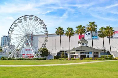a ferris wheel in front of a building with palm trees at Ocean View Suite by Convention Center & Beach in Long Beach