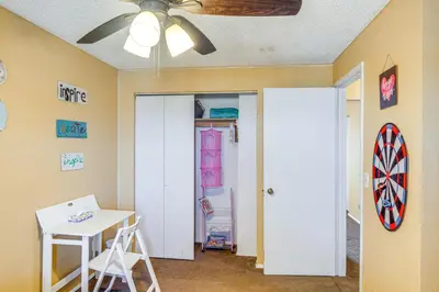 a room with a ceiling fan and a table and a dartboard at Patio and Mtn Views Family Gem in California City in California City
