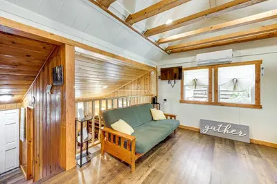 a living room with a green couch and a window at Tiny Home with Deck and Mtn Views in Lake Arrowhead! in Lake Arrowhead