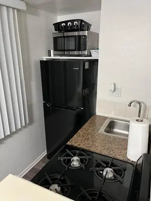 a kitchen with a black stove and a black refrigerator at Starlight Studio near Sunset in Los Angeles
