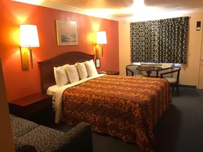 a hotel room with a bed and a chair at Aerospace Inn in Mojave
