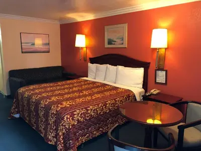 a hotel room with a bed and a table at Aerospace Inn in Mojave