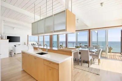 a kitchen and dining room with a view of the ocean at Malibu Cove Colony Beach by Stay Awhile Villas in Malibu