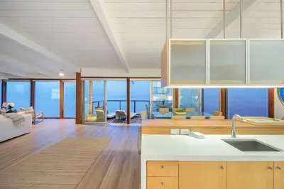 a kitchen and living room with a view of the ocean at Malibu Cove Colony Beach by Stay Awhile Villas in Malibu