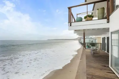 a view of the beach from the balcony of a house at Malibu Cove Colony Beach by Stay Awhile Villas in Malibu
