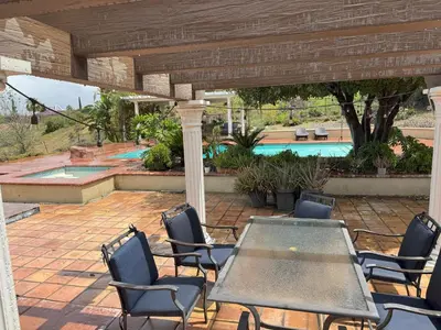 a patio with a table and chairs and a pool at Riverside Views & Pool Retreat in Riverside