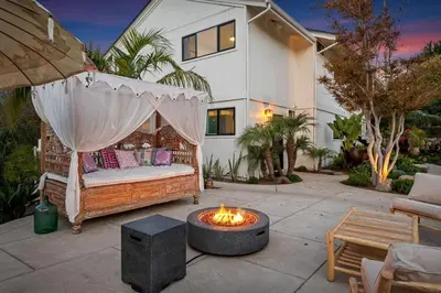 a backyard patio with a bed and a fire pit at Outdoor Spaces and Coastal Sanctuary in Summerland