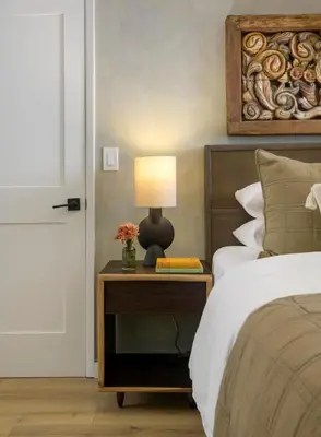 a bedroom with a bed and a table with a lamp at Private Balcony and Coastal Escape in Summerland