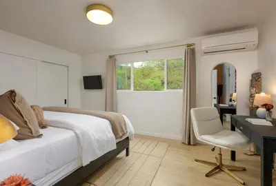 a bedroom with a bed and a desk and a chair at Bali Home and SB Beaches in Summerland