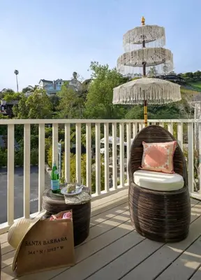 a chair and an umbrella on a deck at Bali Home and SB Beaches in Summerland