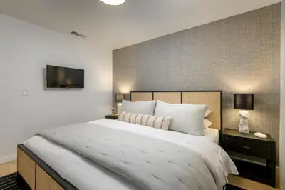 a bedroom with a large bed and a flat screen tv at Group-Friendly and Tranquil Oasis in Summerland