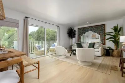 a living room with white furniture and a balcony at Group-Friendly and Tranquil Oasis in Summerland