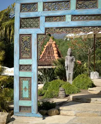 a statue in a garden with a building in the background at Group-Friendly and Tranquil Oasis in Summerland