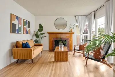 a living room with a couch and a fireplace at Vintage Vibes Near Airport Games Sleeps 8 in Long Beach