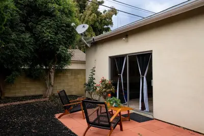 a patio with two chairs and a table in front of a house at Vintage Vibes Near Airport Games Sleeps 8 in Long Beach