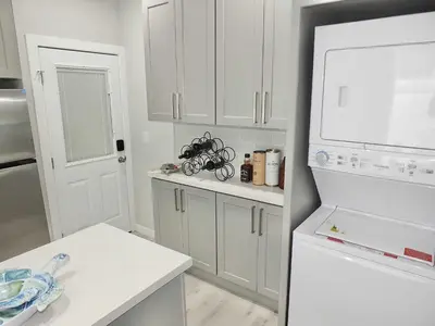 a kitchen with white cabinets and a white refrigerator at Beach & Bay Retreat - Full of Amenities in Long Beach