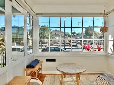 a room with a large window with a table and benches at Beach City Craftsman - Walk to Beach in Long Beach