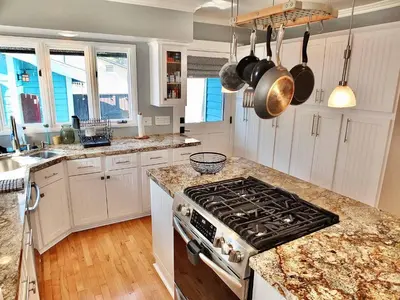 a kitchen with white cabinets and a stove top oven at Beach City Craftsman - Walk to Beach in Long Beach