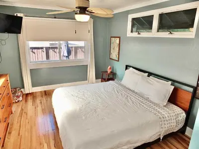a bedroom with a white bed and two windows at Beach City Craftsman - Walk to Beach in Long Beach