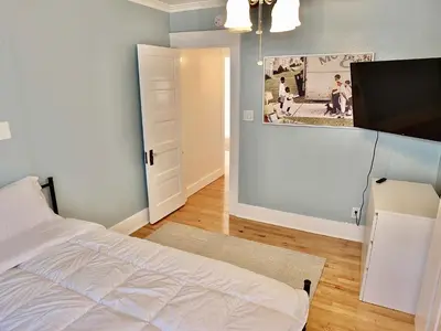 a bedroom with a bed and a painting on the wall at Beach City Craftsman - Walk to Beach in Long Beach
