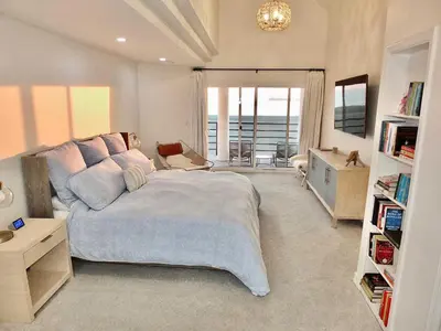 a bedroom with a large bed and a view of the ocean at Beachfront Estate - LB Peninsula in Long Beach